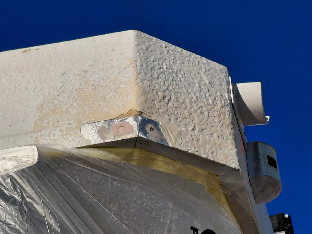 Houseboat hull corner with deteriorated coating and structural damage before repair