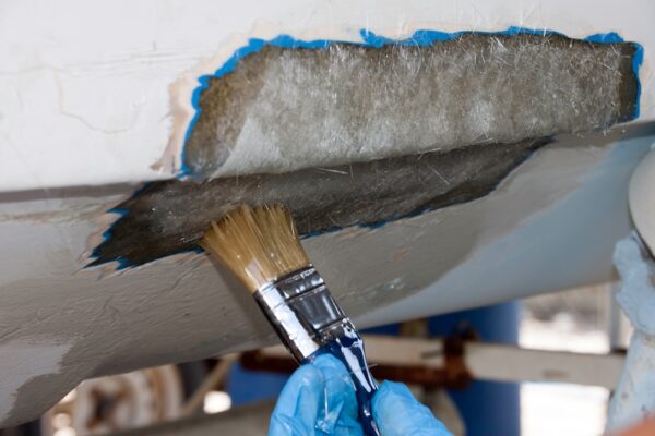 A worker is applying epoxy to polyester pach